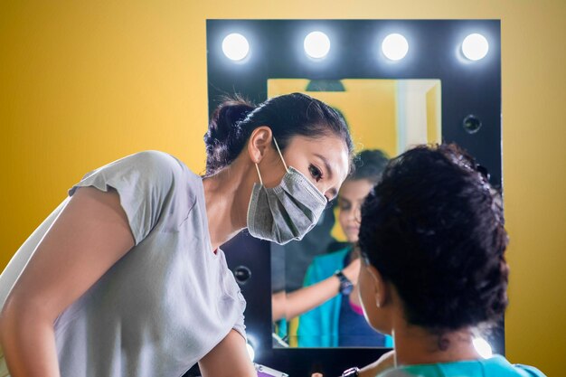 Foto makeup artist prepares her model before photoshoot