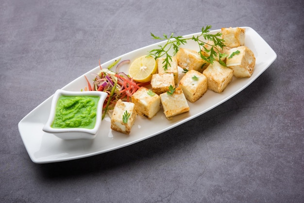 Makhmali o Malai Paneer Tikka Kabab es un aperitivo del norte de la India que se sirve con ensalada verde y salsa picante.