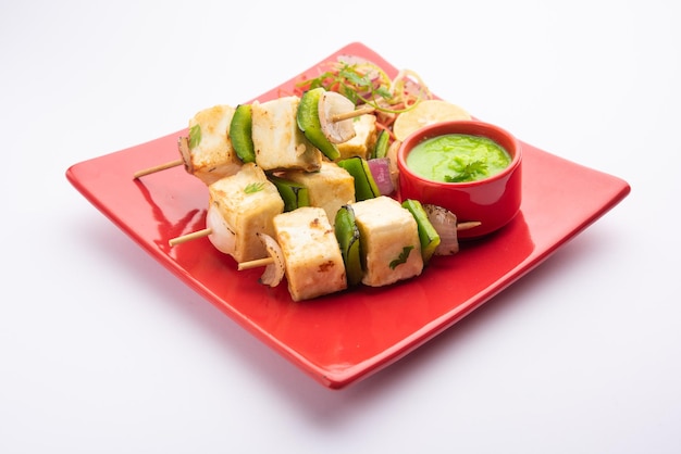 Makhmali o Malai Paneer Tikka Kabab es un aperitivo del norte de la India que se sirve con ensalada verde y salsa picante.