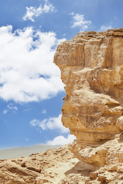 Makhtesh Ramon - Cratera Ramon no deserto de Negev, em Israel, do mirante Mitzpe Ramon, com o Monte Ramon ao fundo. Vista da areia colorida, pedra do deserto do Negev, descendo do penhasco.