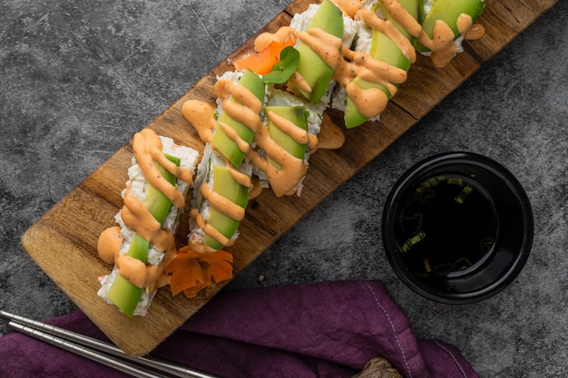 Maki roll con aguacate y sésamo por fuera, queso por dentro y salsa dulce