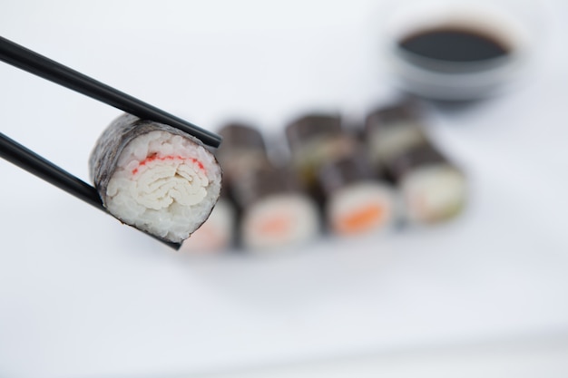 Maki sushi retenido en palillos de madera