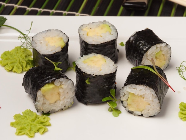 Maki-Sushi-Rollen mit Avocado auf einer weißen Plattennahaufnahme