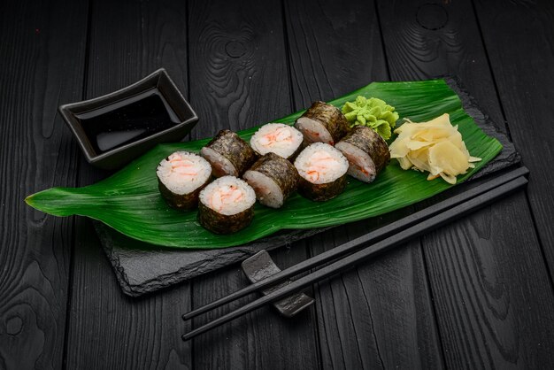 Maki-Sushi-Rollen mit Garnelen auf schwarzem Hintergrund