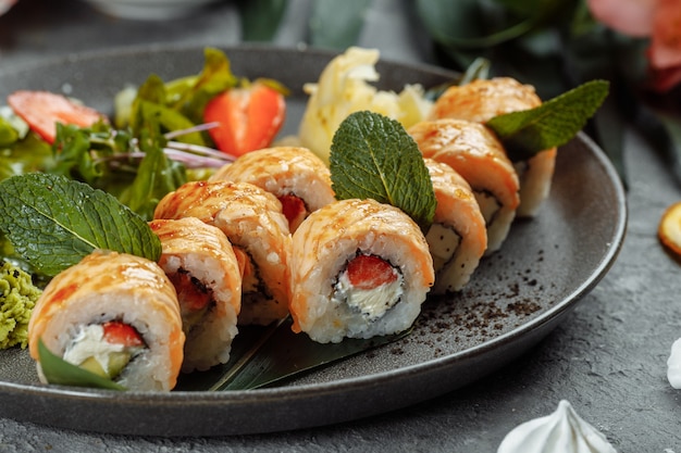 Maki Sushi: un rollo de queso crema, fresas, aguacate y salmón frito. Rollos de sushi de temporada de verano.