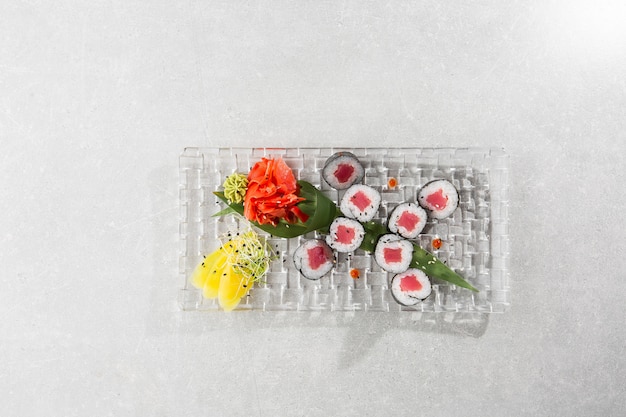 Maki Sushi Rolls con atún servido en plato transparente.