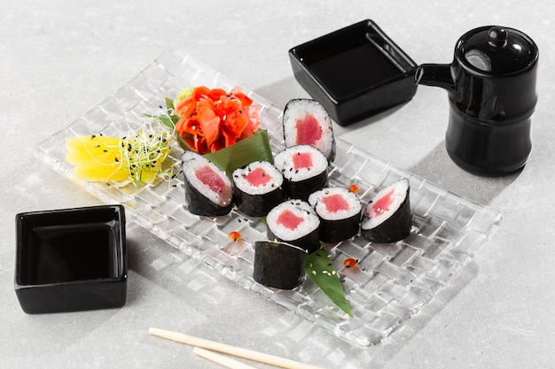 Maki Sushi Rolls mit Thunfisch auf transparentem Teller serviert.