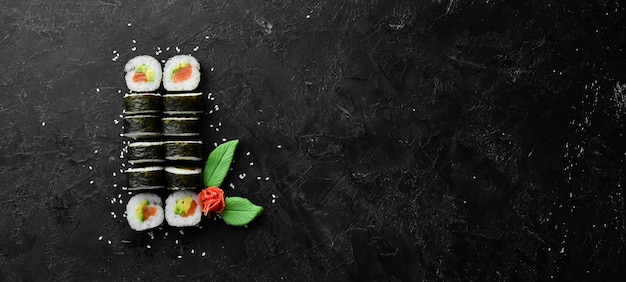 Maki de sushi con salmón, aguacate y nori Espacio libre para el texto Cocina tradicional japonesa Vista superior Estilo rústico