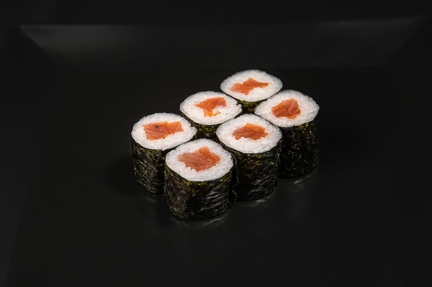 Maki sushi sobre fundo preto