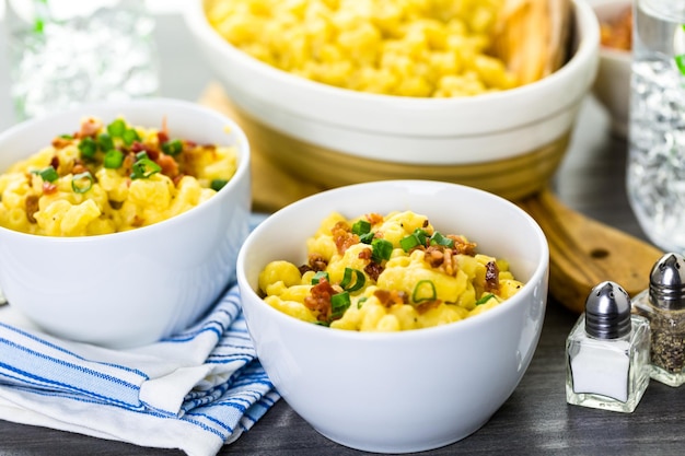 Makkaroni und Käse garniert mit Speckstückchen und Schnittlauch.