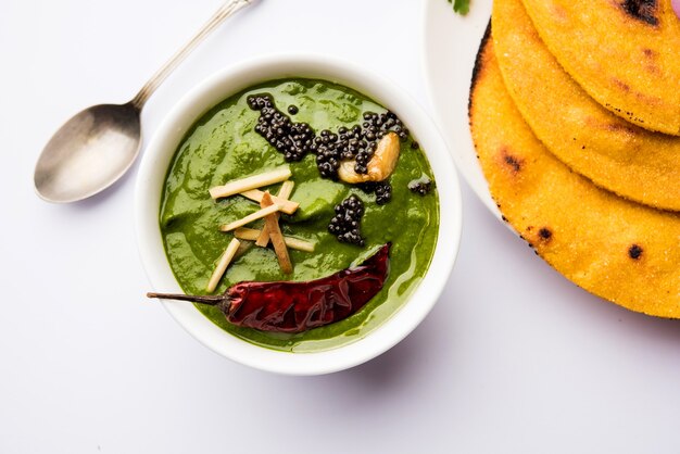 Makki di roti com sarson ka saag, receita de prato principal de punjabi popular no inverno feita com curry de folhas de mostarda de pães de milho. servido sobre fundo temperamental. foco seletivo