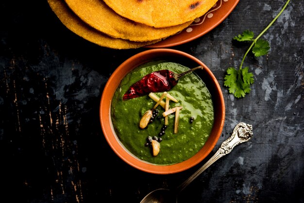 Makki di roti com sarson ka saag, receita de prato principal de punjabi popular no inverno feita com curry de folhas de mostarda de pães de milho. servido sobre fundo temperamental. foco seletivo