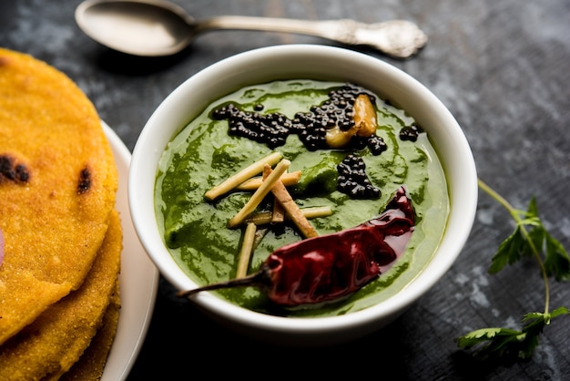 Makki di roti com sarson ka saag, receita de prato principal de punjabi popular no inverno feita com curry de folhas de mostarda de pães de milho. servido sobre fundo temperamental. foco seletivo