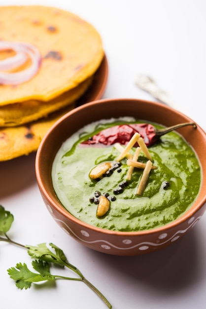 Makki di roti con sarson ka saag, receta popular de plato principal punjabi en inviernos hecha con pan de maíz, hojas de mostaza y curry. servido sobre un fondo de mal humor. enfoque selectivo