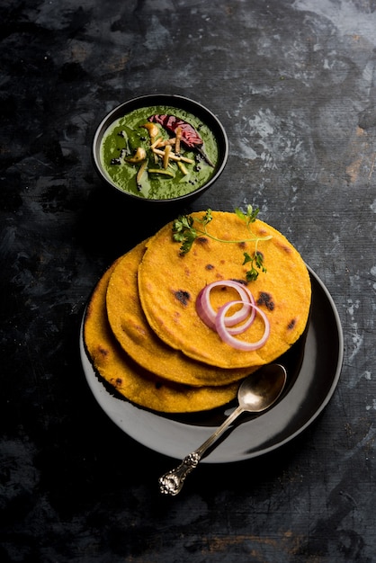 Makki di roti con sarson ka saag, receta popular de plato principal punjabi en inviernos hecha con pan de maíz, hojas de mostaza y curry. servido sobre un fondo de mal humor. enfoque selectivo