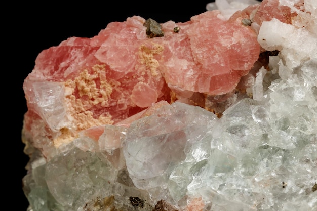 Makro des Mineralsteins Rhodochrosit mit Fluorit auf schwarzem Hintergrund