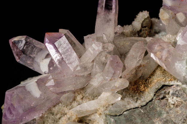 Makro-Mineralstein Amethyst-Kristalle im Felsen auf schwarzem Hintergrund