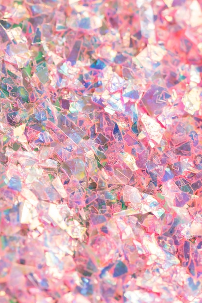 Makro-Nahaufnahme des zerschmetterten rosa holographischen Konfetti-strukturierten Hintergrunds