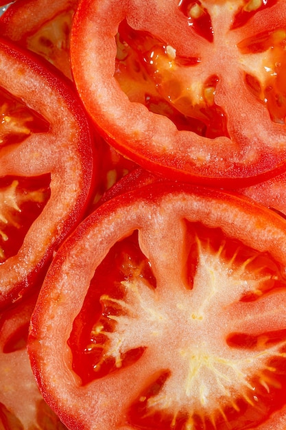 Foto makro rote tomaten, natürlicher hintergrund tomatenscheiben mit tomatenscheiben