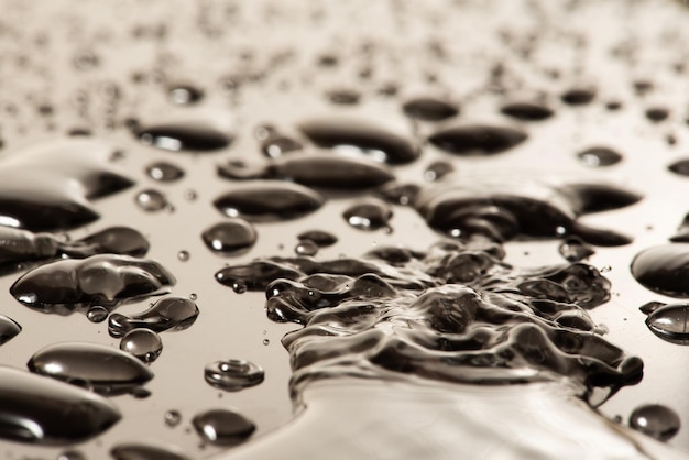 Makro-Wassertropfen Makrofoto von Wassertropfen auf einer reflektierenden Oberfläche mit selektivem Fokus