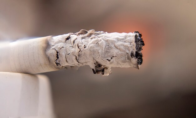 Makroansicht der brennenden Zigarette mit Rauche.