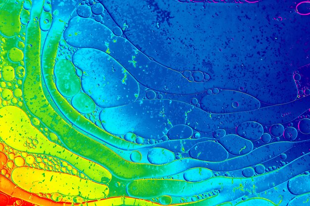 Makroaufnahme einer Wasser-Öl-Emulsion auf farbigem Hintergrund