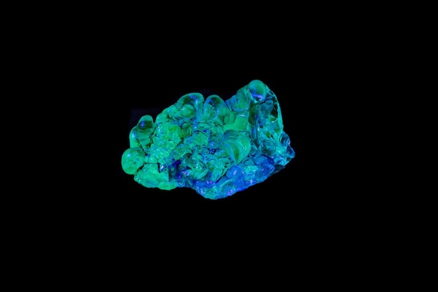 Makromineralsteinopal unter ultraviolettem Licht auf schwarzem Hintergrund