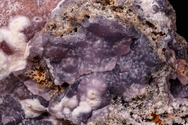 Makrorosa Smithsonit-Mineralstein auf Mikrokline auf schwarzem Hintergrund