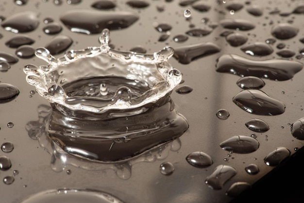 Makrospritzer Makrofoto eines Wassertropfens, der auf eine reflektierende Oberfläche fällt, selektiver Fokus