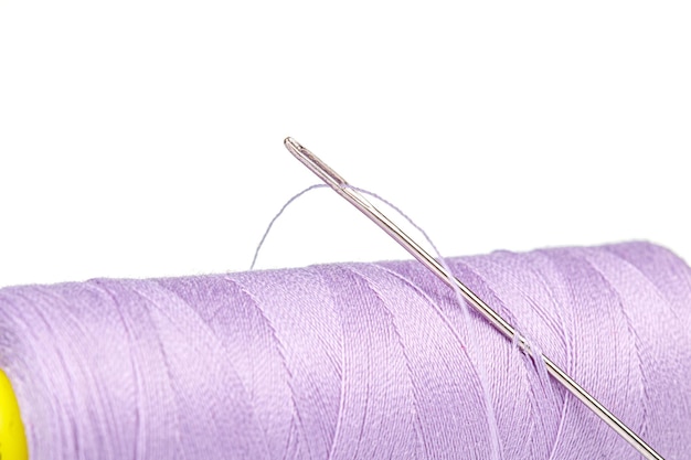 Makrostrang Faden lila Farben mit einer Nadel auf weißem Hintergrund