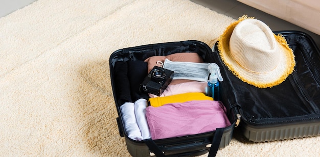 Mala aberta com roupas de viajante e acessórios de coisas prontas para embalar nas férias de verão