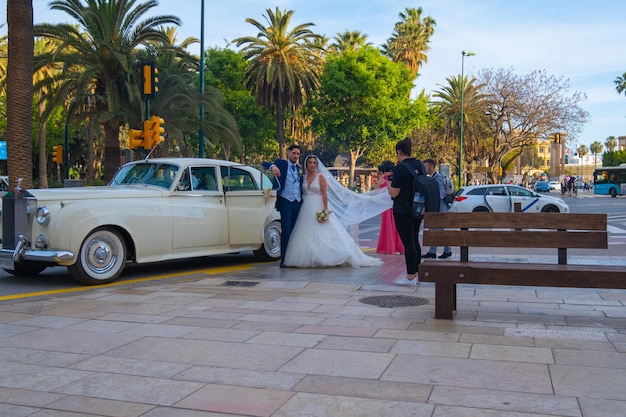 Foto málaga, espanha, 30 de abril de 2022 fotógrafo de casamento tira fotos dos noivos no centro da cidade o fotógrafo em ação