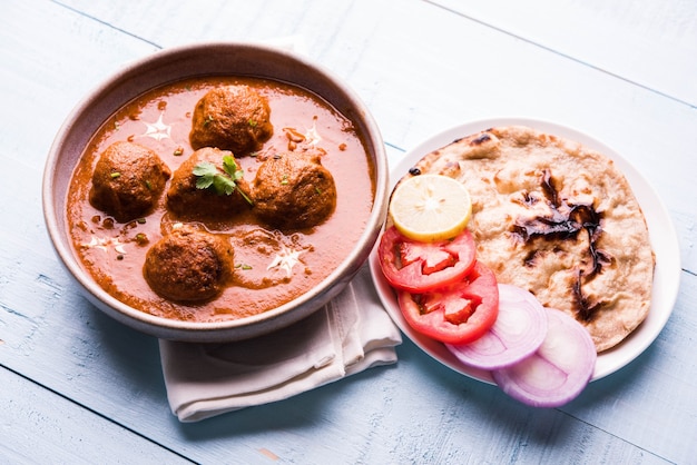 Malai Kofta Curry - klassisches nordindisches Gericht. vegetarische Alternative zu Frikadellen serviert mit Tandoori Roti oder indischem Brot und grünem Salat, selektiver Fokus