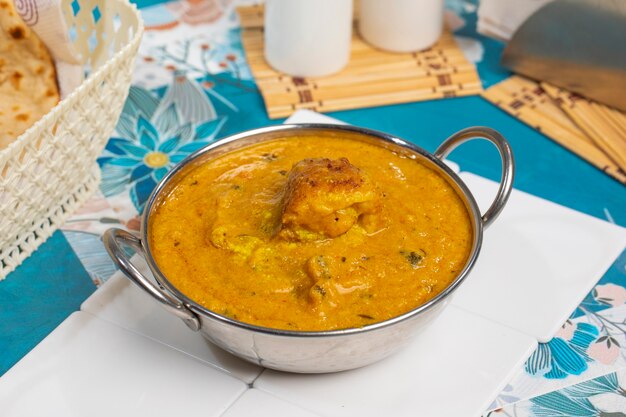 Malai kofta curry na tigela em fundo branco. malai kofta é um famoso prato da cozinha indiana com bolinhos fritos de batata, paneer e queijo em molho de tomate e cebola com especiarias indianas picantes