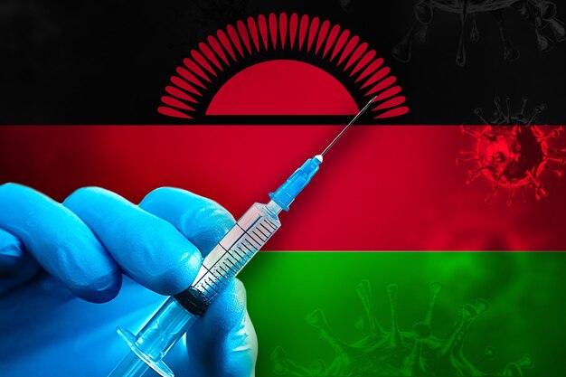 Malawi Covid19-Impfkampagne Hand in einem blauen Gummihandschuh hält Spritze vor Flagge