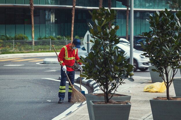 Malaysischer Hausmeister, der auf der Straße der Stadt Kuala Lumpur arbeitet