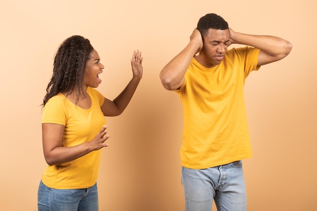 Malentendido en pareja matrimonio familia Furiosa dama negra gritando a su hombre molesto fondo de estudio de melocotón