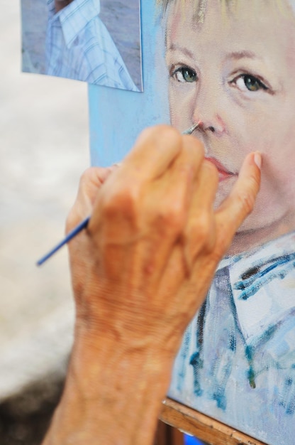 Maler, der ein Porträt mit Pinsel und feinen Details anfertigt