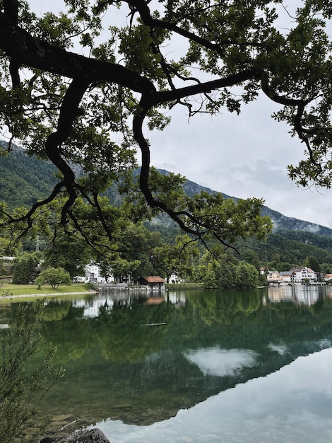 Malerische Aussicht auf den See mit Bergen und Wolkenspiegelungen. Altes kleines Dorf. Malerische Naturlandschaft. Sommerurlaubsreise