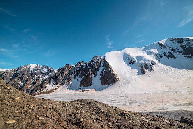 Malerische Berglandschaft mit großem Gletscher im Sonnenlicht Ehrfürchtige verschneite Landschaft mit Gletscherzunge unter Zirruswolken Wunderschöner Alpenblick auf schneebedeckte Berggipfel in sehr großer Höhe an sonnigen Tagen