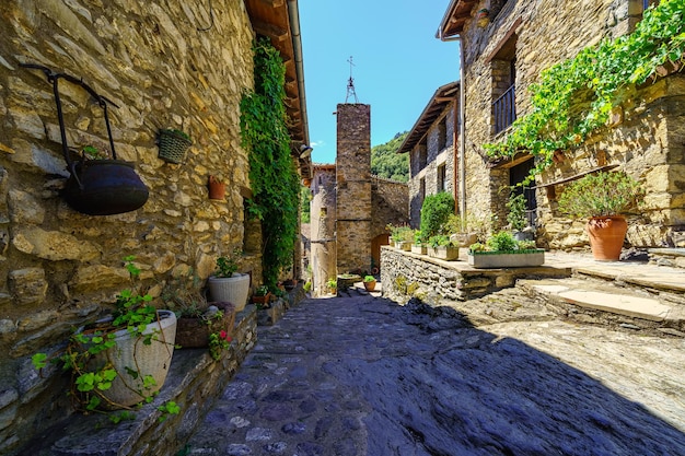 Malerische Gasse mit Häusern aus Stein und Töpfen mit Blumen im mittelalterlichen Dorf Beget Girona Katalonien