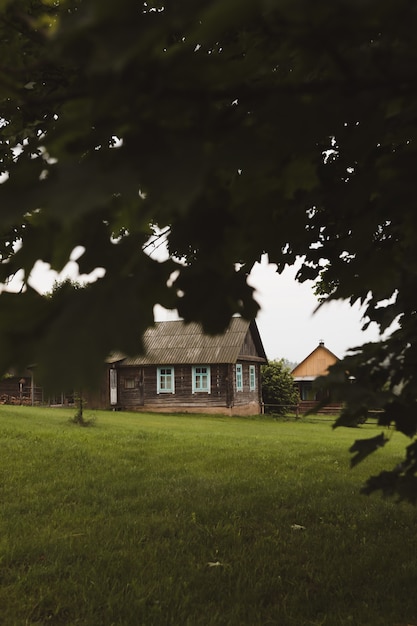 Malerische ländliche Landschaft des Sommers mit einem hölzernen Landbauernhaus