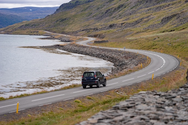 Malerische Landschaft mit Autofahrt durch schöne Straße, Fjord und Küste von Island Westfjord.