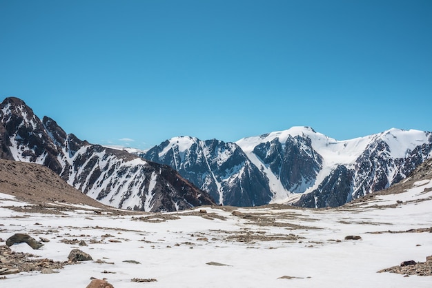 Malerische Landschaft mit schneebedeckter Bergspitze Wunderbare Aussicht vom Berg stonu snowu auf die Bergkette unter blauem Himmel an sonnigen Tagen Fantastische Landschaft mit schneebedeckten Bergen im Sonnenlicht in sehr großer Höhe