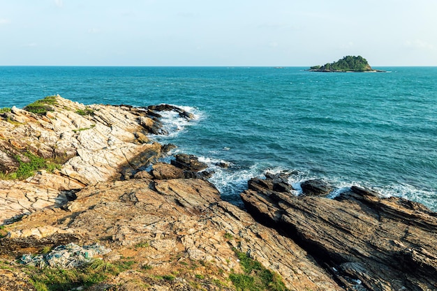 Malerische Meereslandschaft mit Felsformationen und steiniger Küste, umspült von blauen Wellen aus türkisfarbenem Meer vor wolkenlosem Himmel in der Natur