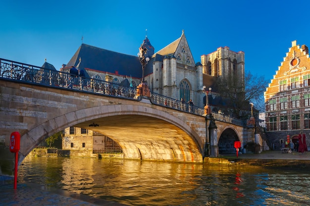 Malerische mittelalterliche St.-Michael-Brücke und Kirche bei Sonnenaufgang in Gent, Belgien