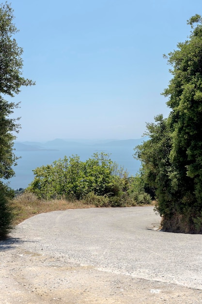 Malerische schmale Straße in den Bergen mit einer scharfen Kurve und Blick auf das Meer