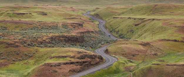 Malerische Straße auf dem Land durch grüne Felder