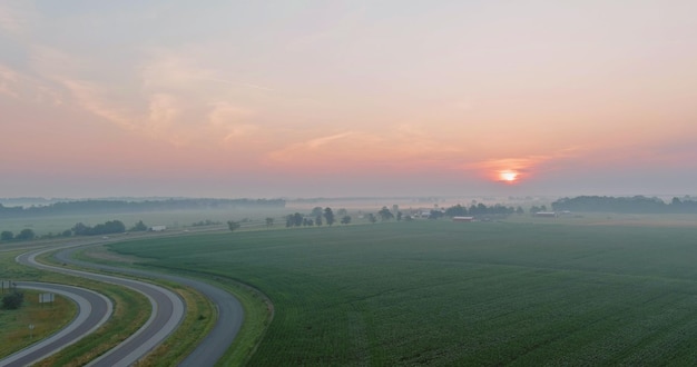 Malerische Wiese mit Sonnenaufgang am frühen Morgen über der Hochgeschwindigkeitsautobahn