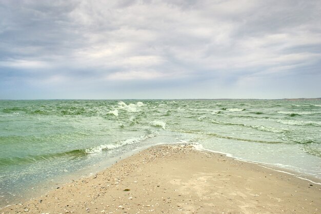 Malerischer Meerblick mit Wellen und leerem Strand.